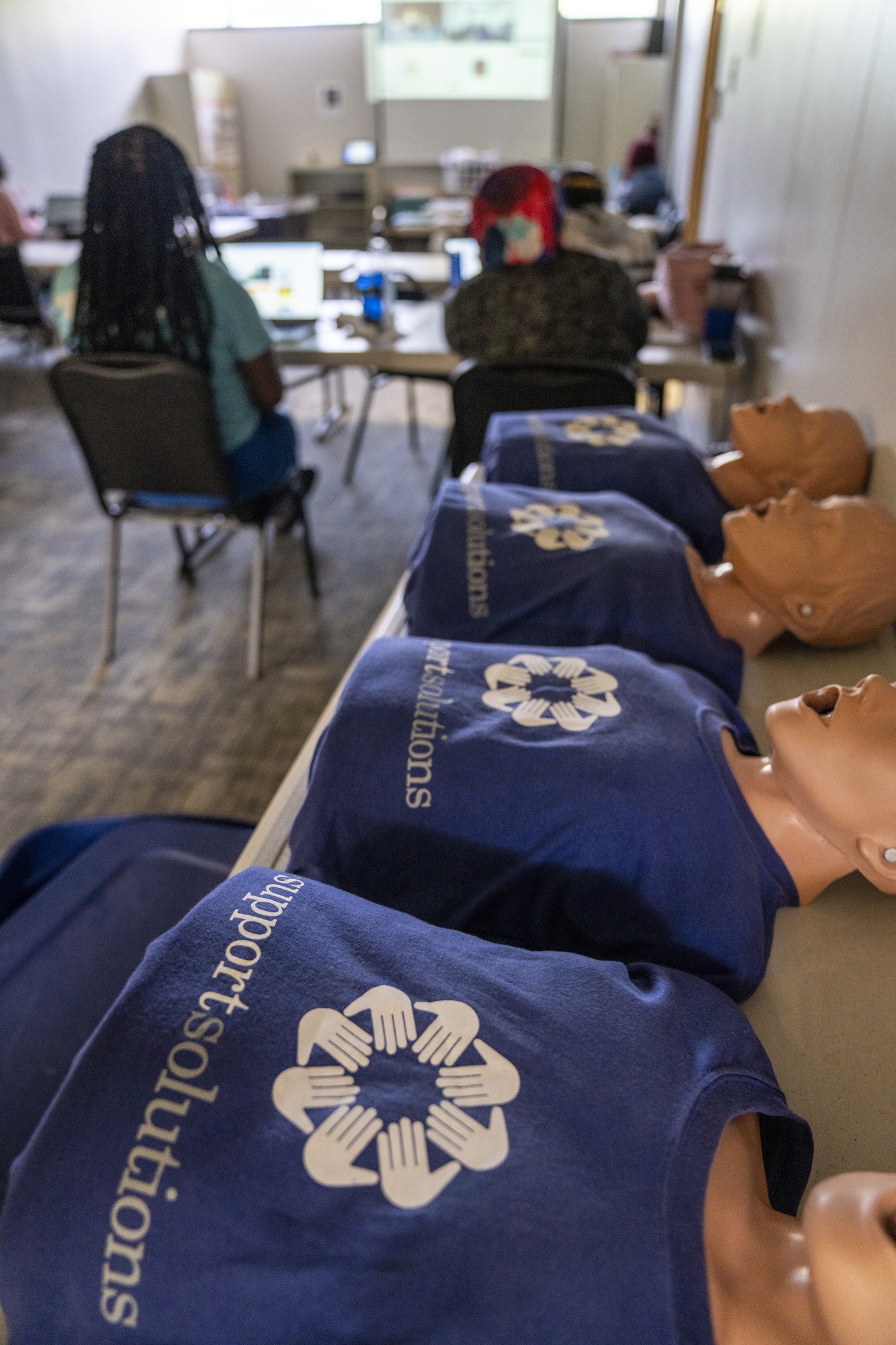 CPR practice mannequins prepared for a Support Solutions orientation session.